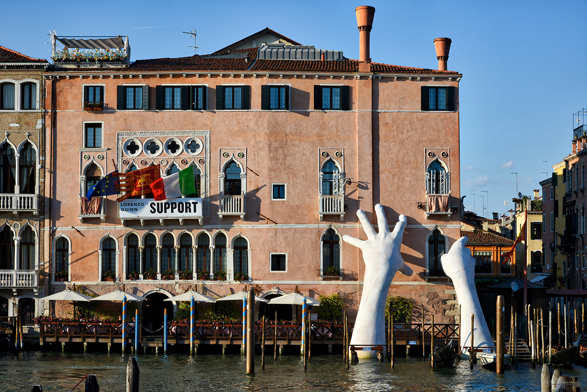 Sculpture of hands against a building