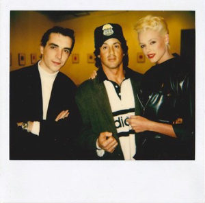 polaroid of two men and a woman