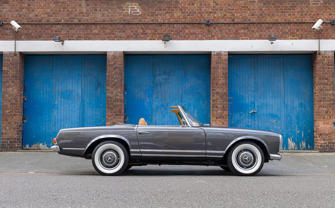 classic car parked outside blue doors