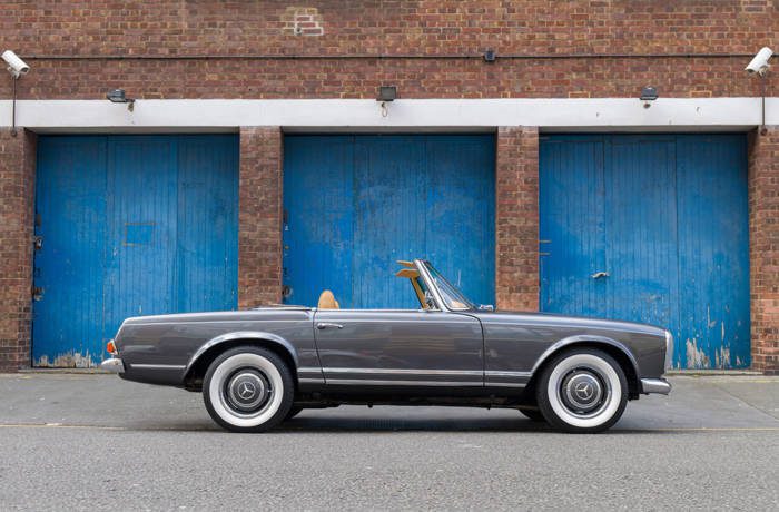 classic car parked outside blue doors