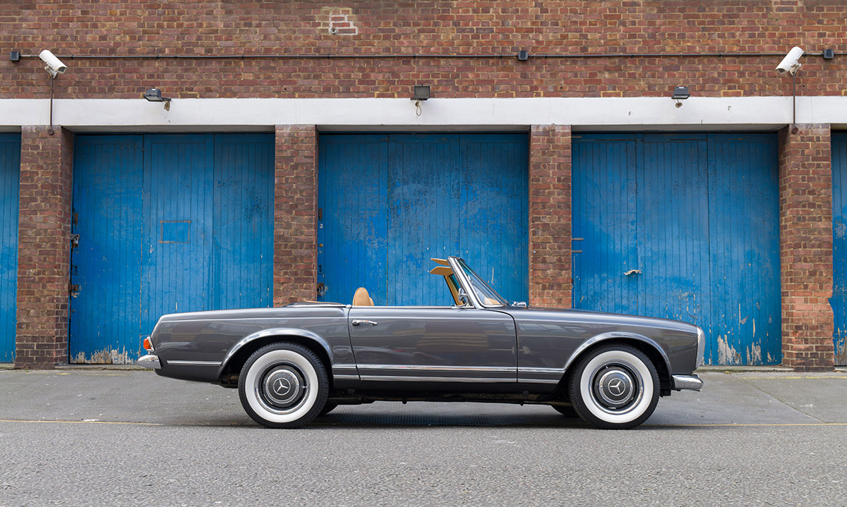 classic car parked outside blue doors