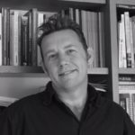 man in front of book case