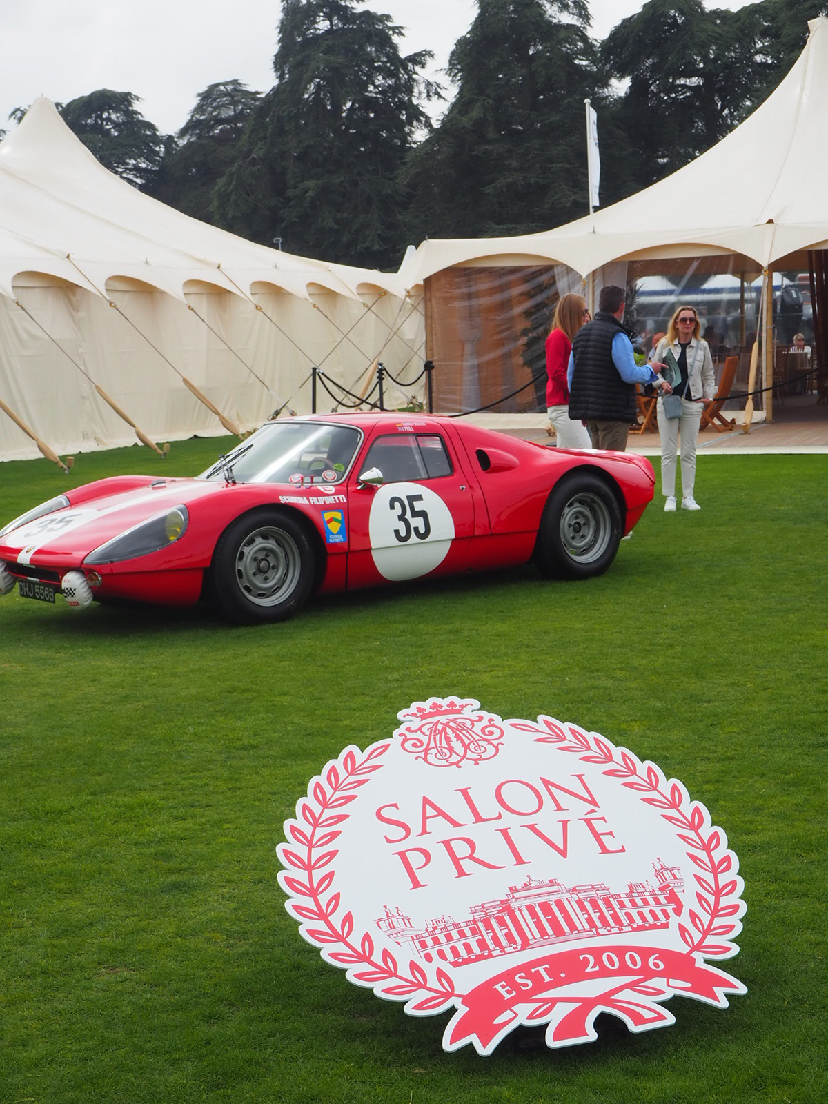 red racing car parked outside marquee