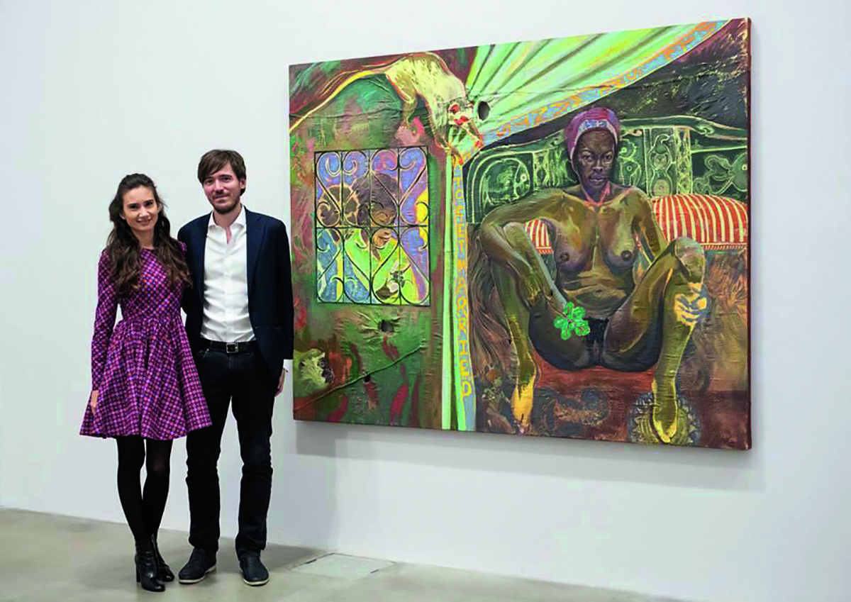 couple standing next to artwork