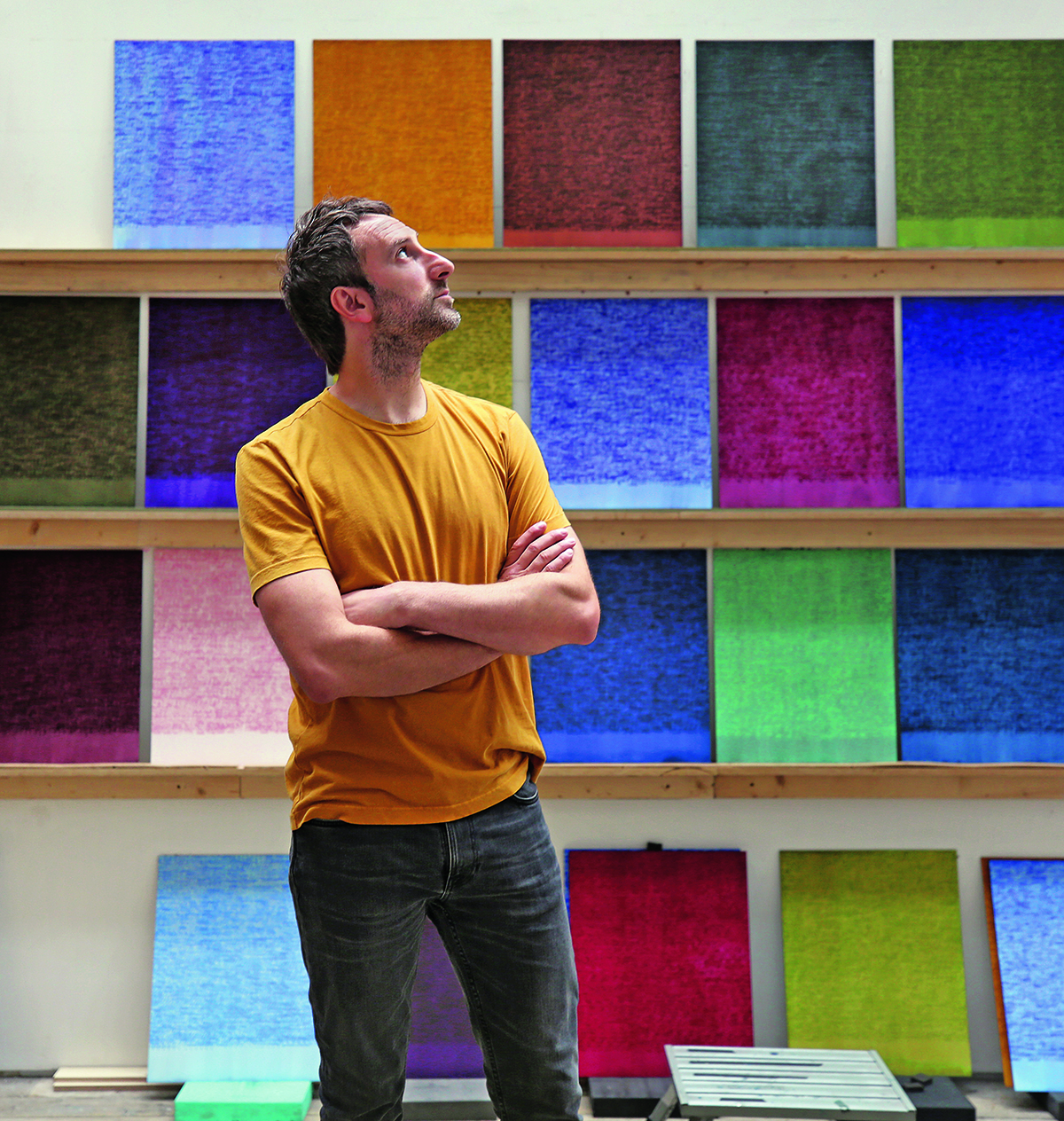 man standing in front of colourful artworks
