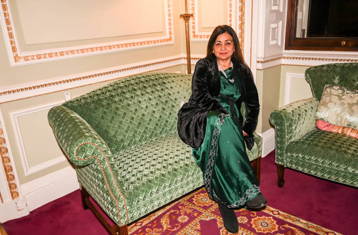 woman sitting on a green couch in a green dress