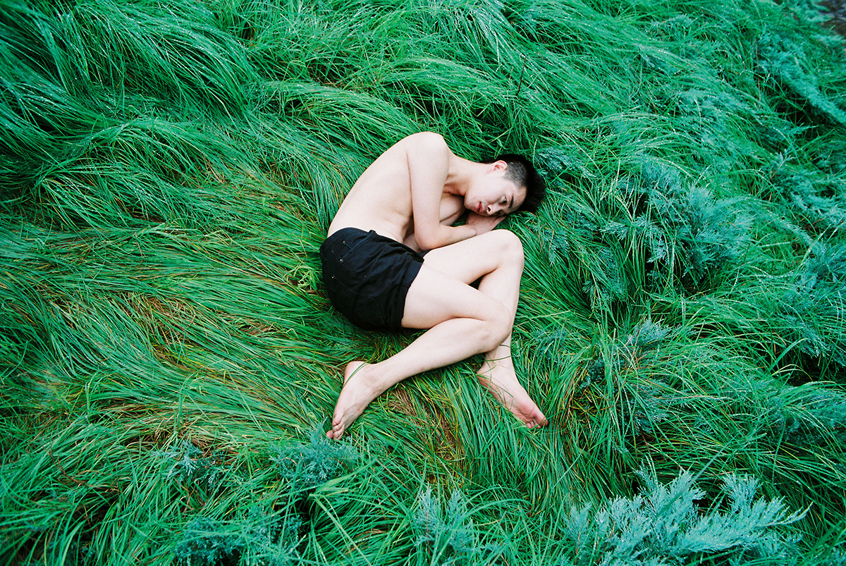 a man wearing black shorts lying on the grass