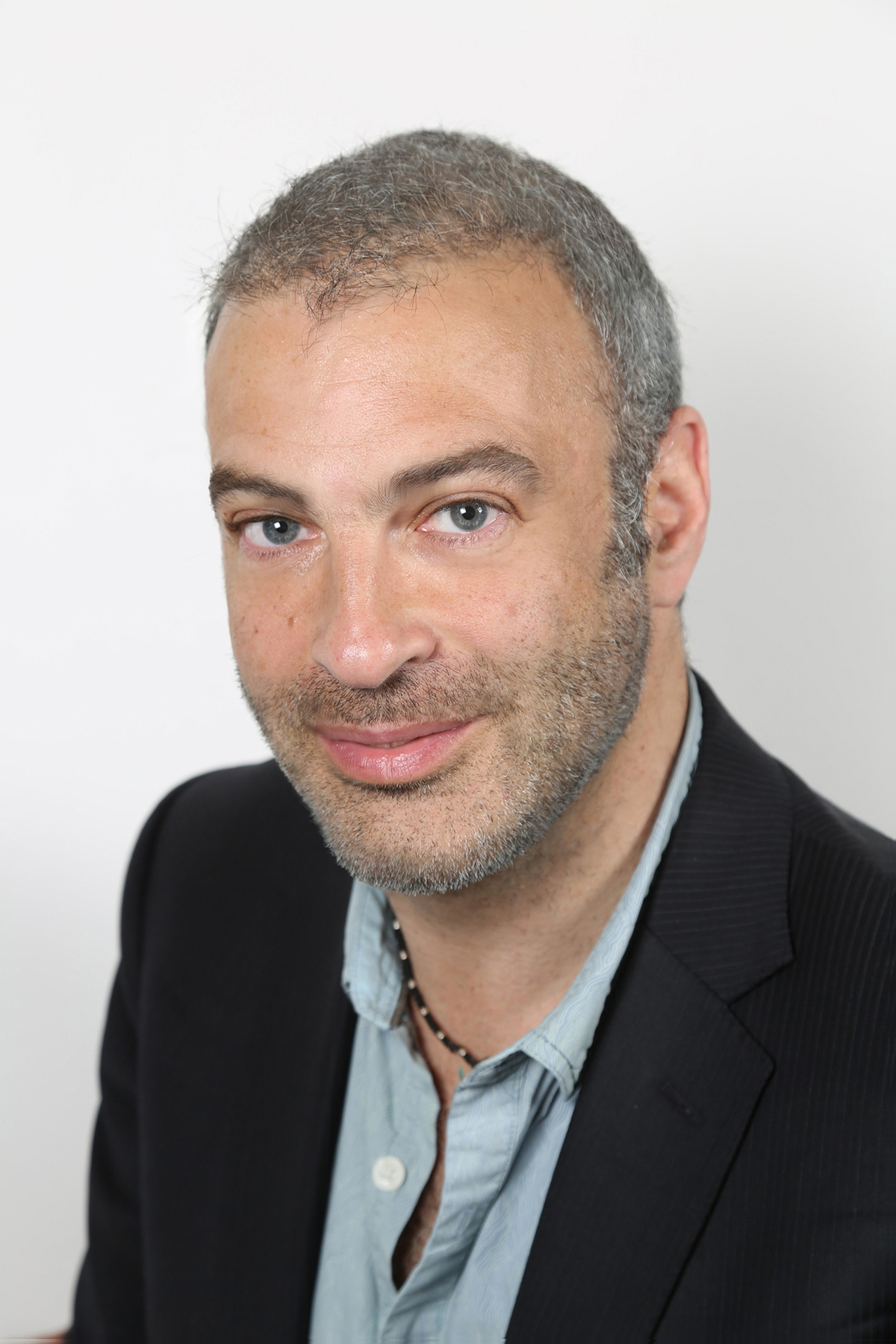 a man in a green shirt and black blazer