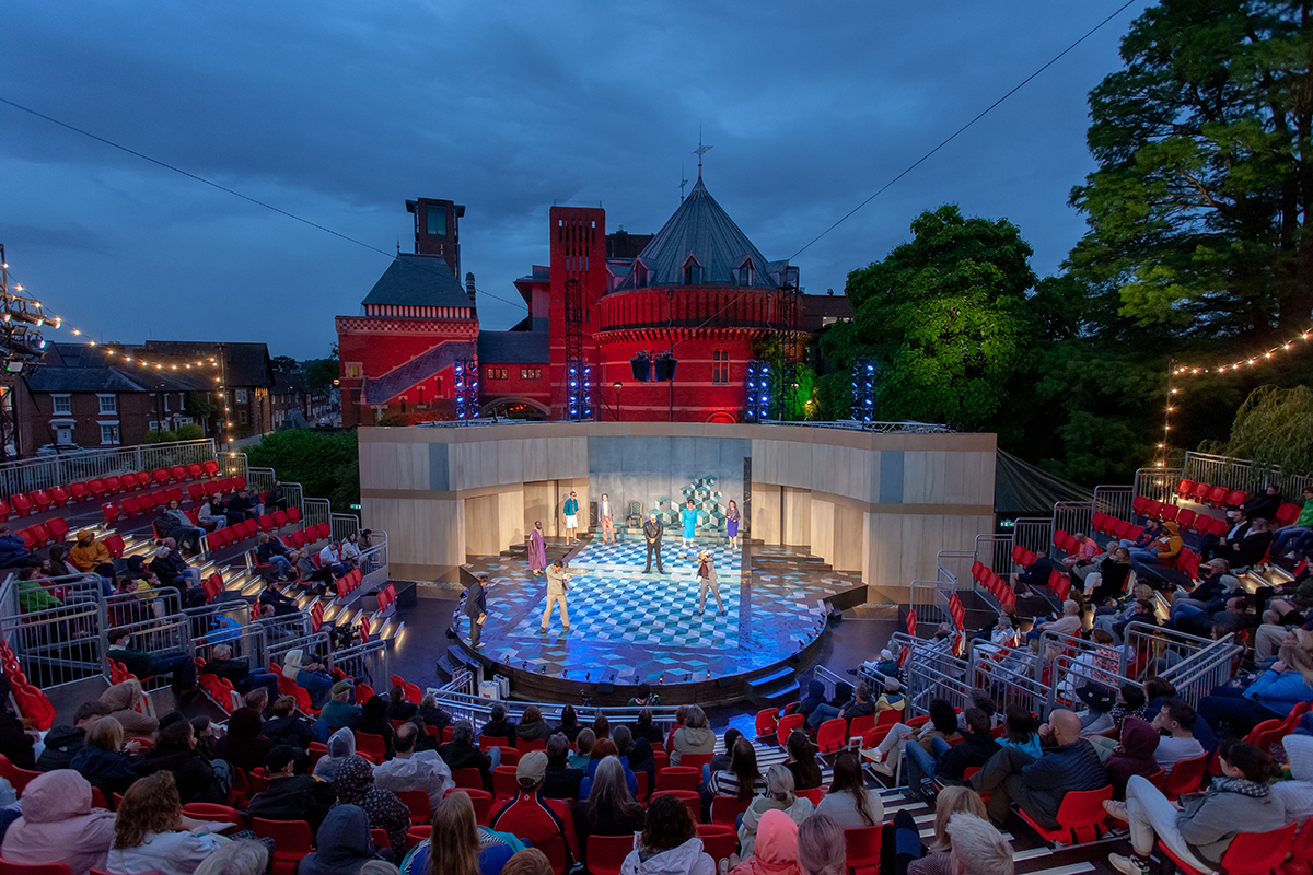 A castle behind and stage with red seats and lights around