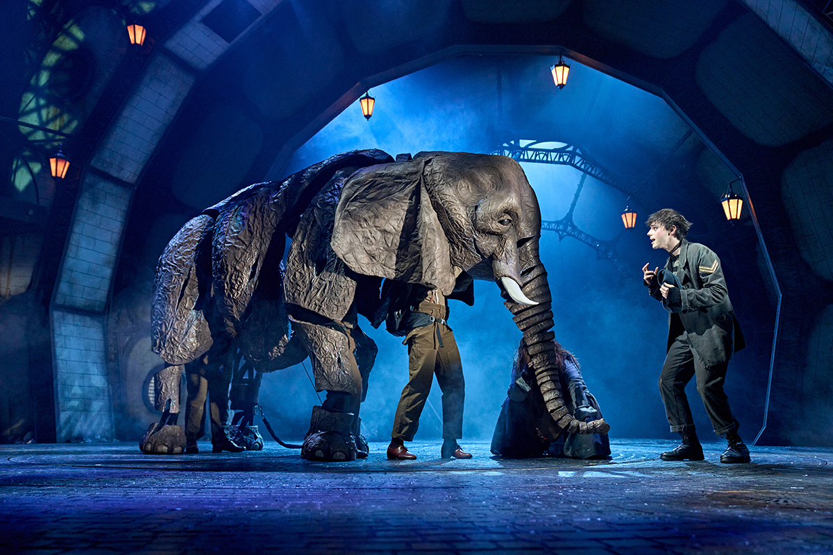 a fake elephant and a boy on a stage for a musical