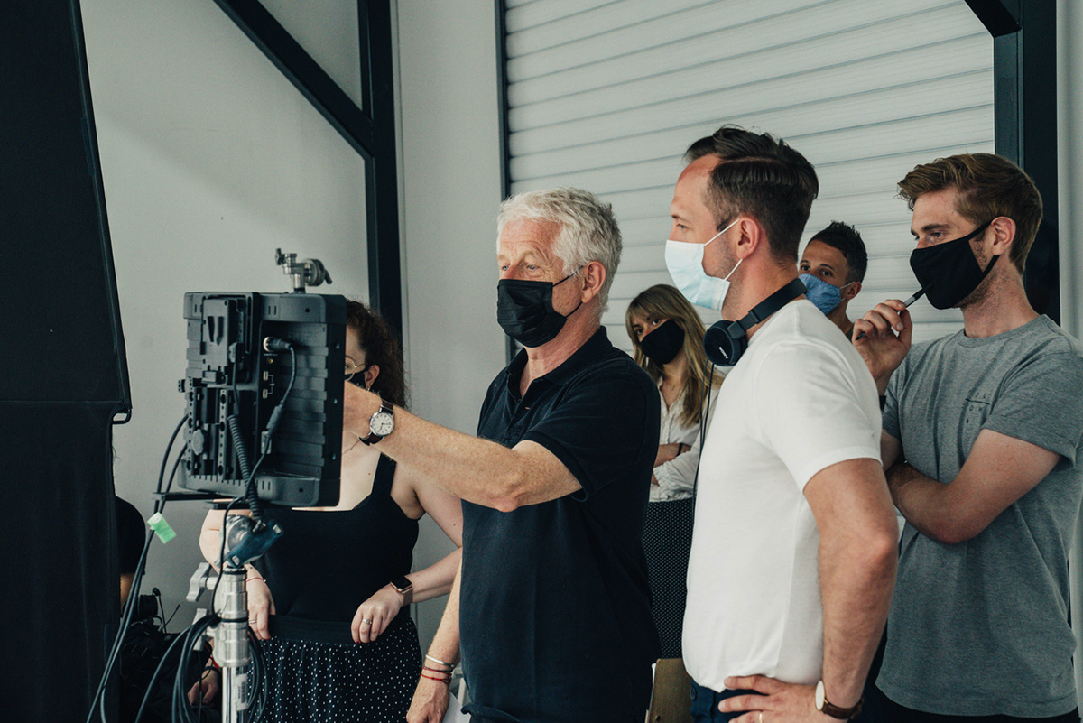 Richard Curtis working on a set with a camera crew