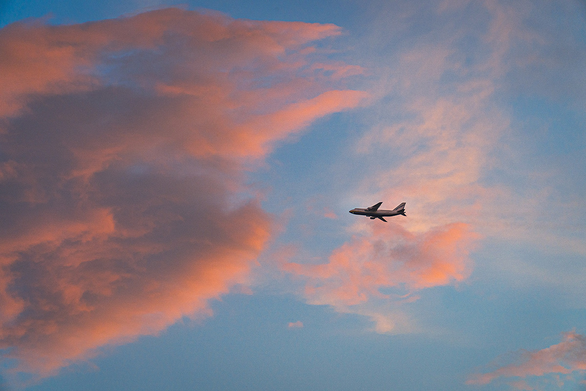 plane in the sky with pink clouds