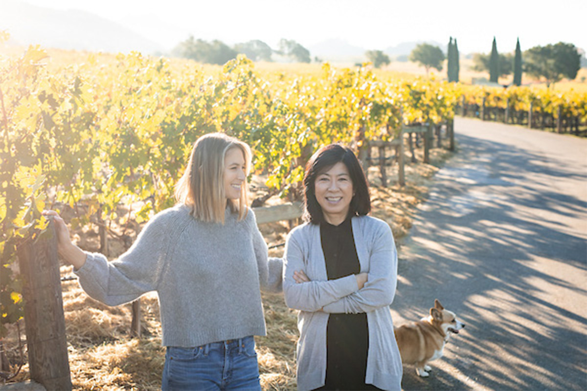 Two women standing in a vineyard