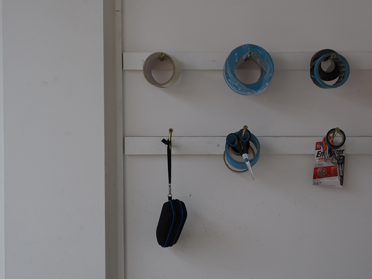 Tape and paint tools hanging on a wall