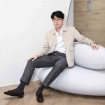 Michael Xufu Huang sitting on a sofa