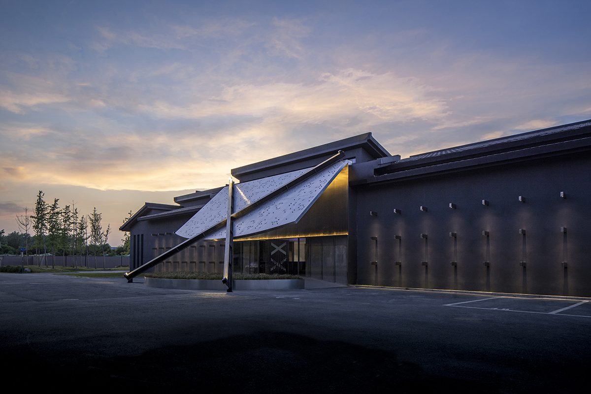 X Museum Exterior with lights shining against the building and a large X in the middle