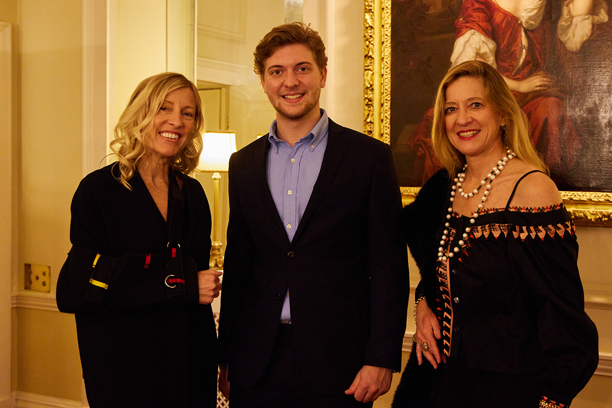 A boy standing between two women