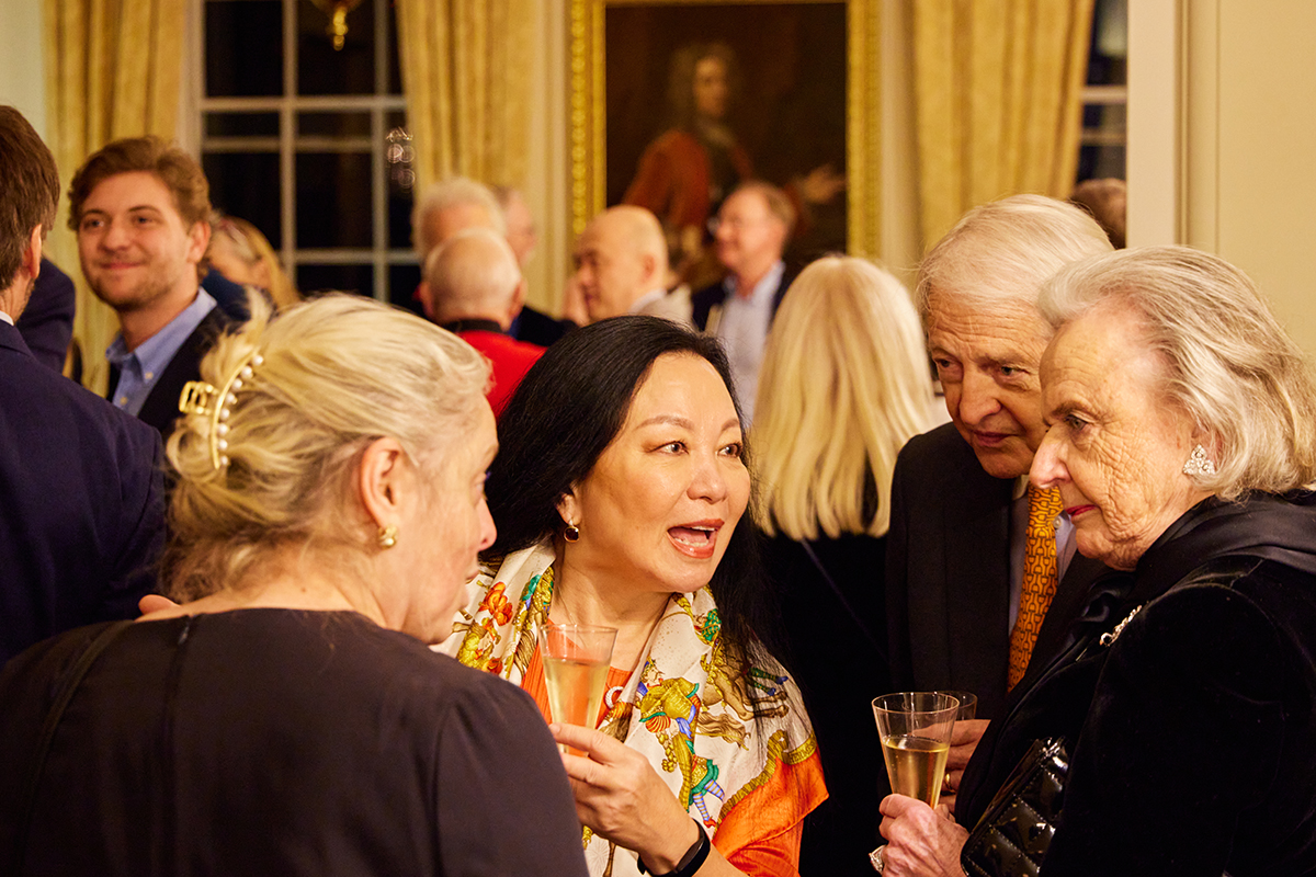 An asian woman talking to a group of people