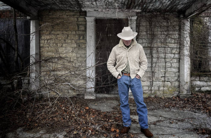 man standing in jeans and a cowboy hat