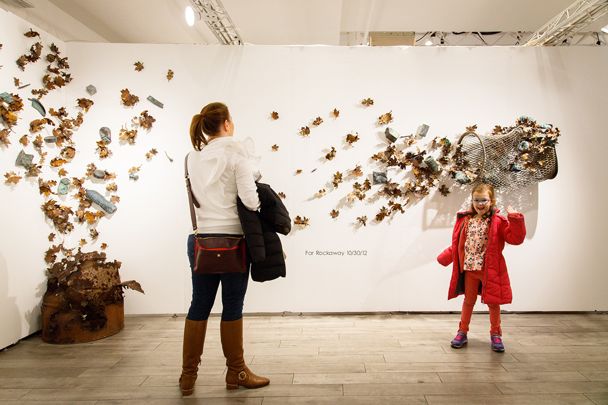 A mother and child standing in front of a wall installation