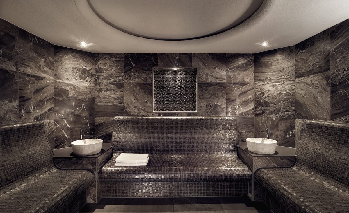 A bronze tiled sauna space with white towels