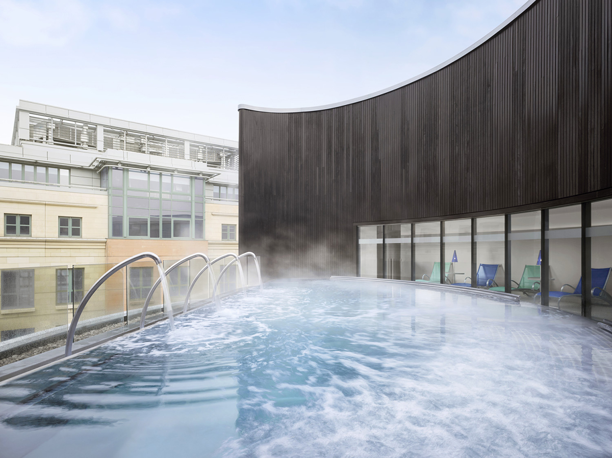 An outdoor rooftop pool with steam coming out of it