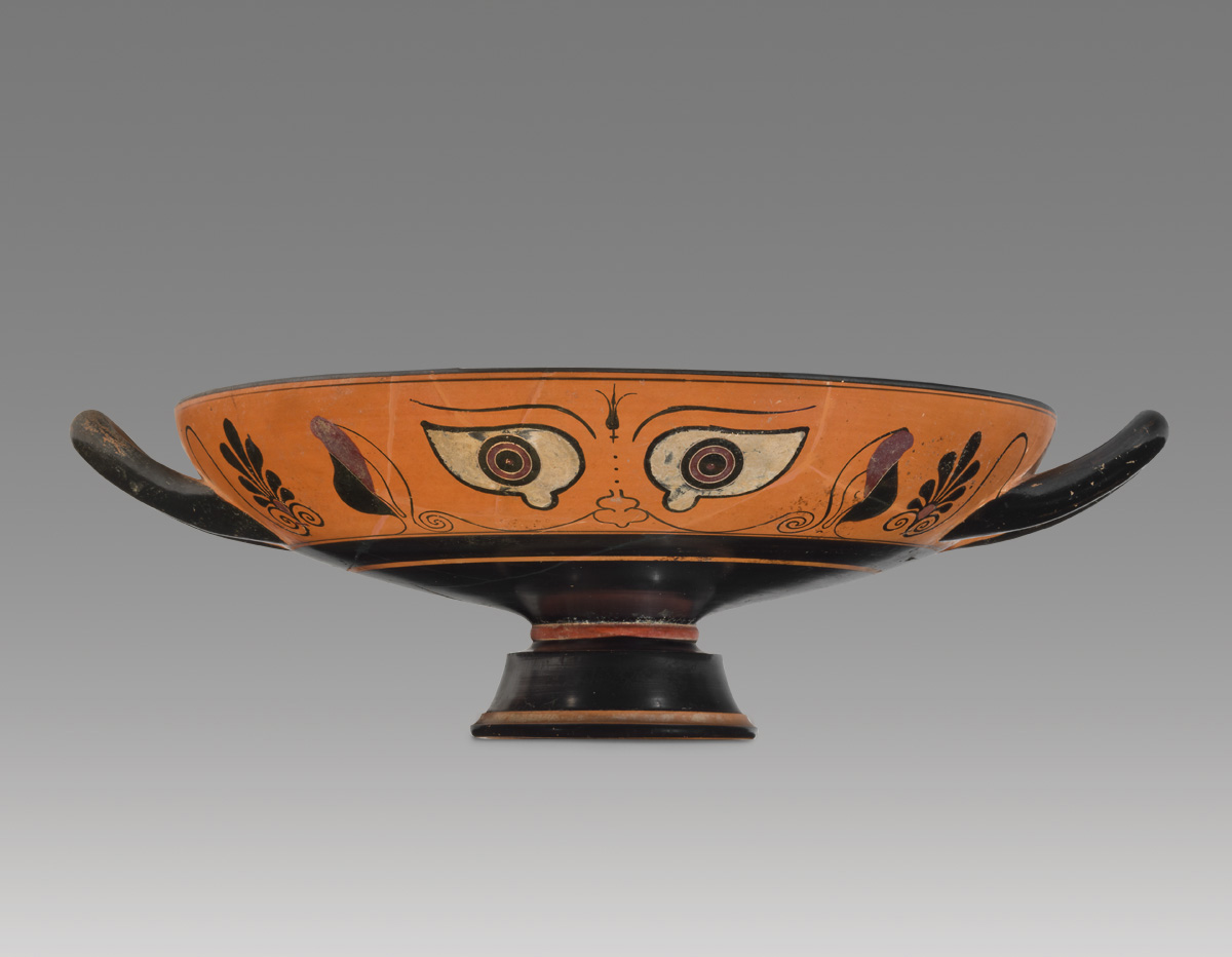 An orange vase with eyes on the side