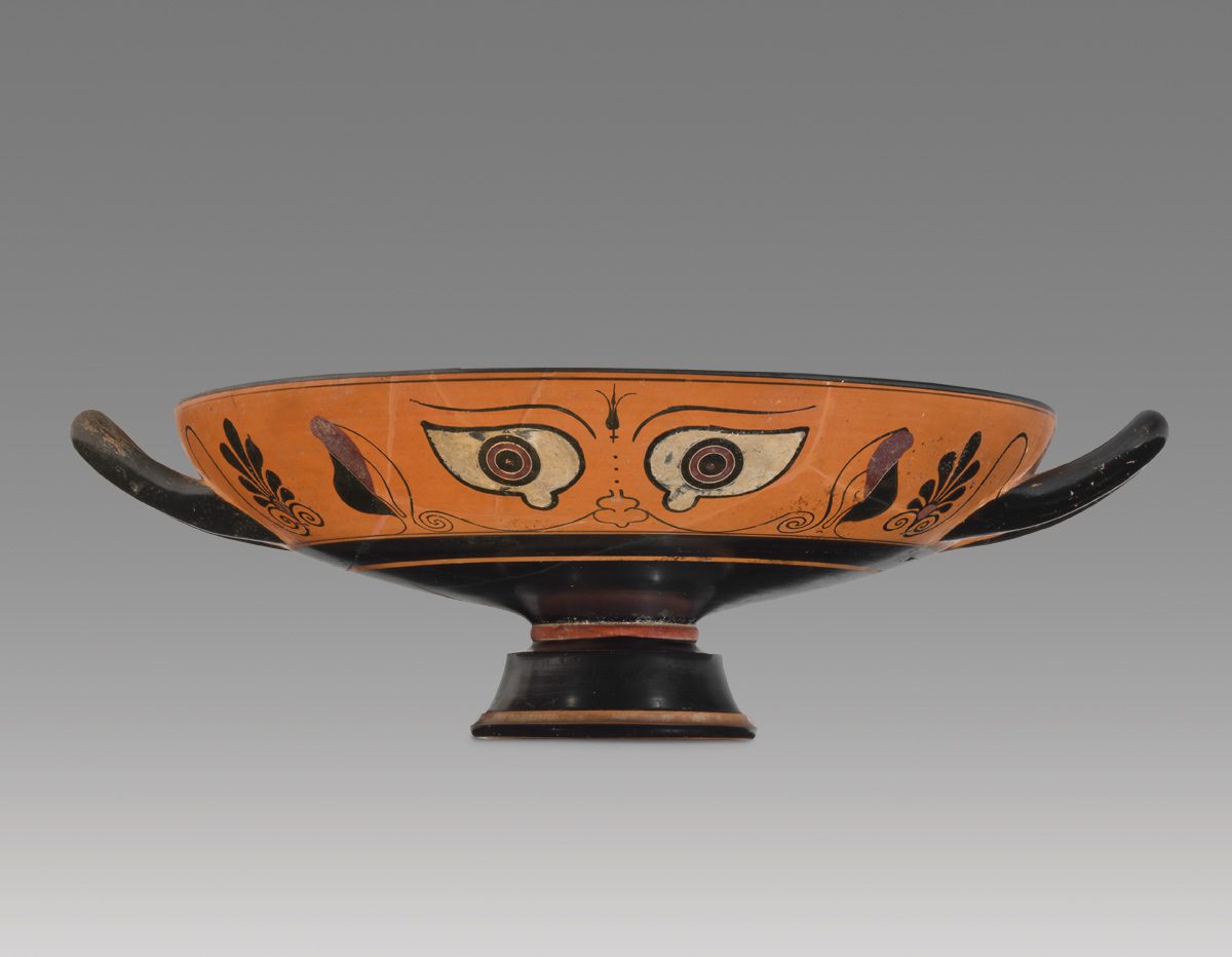 An orange vase with eyes on the side