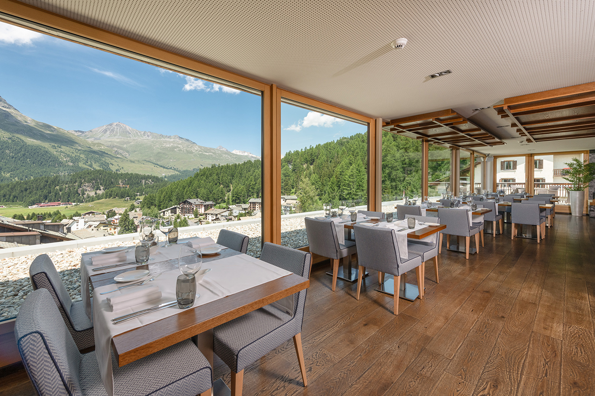 a wooden restaurant with a panoramic view of the mountains