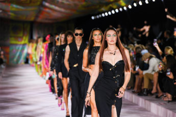 A catwalk with all the models walking down in black dresses