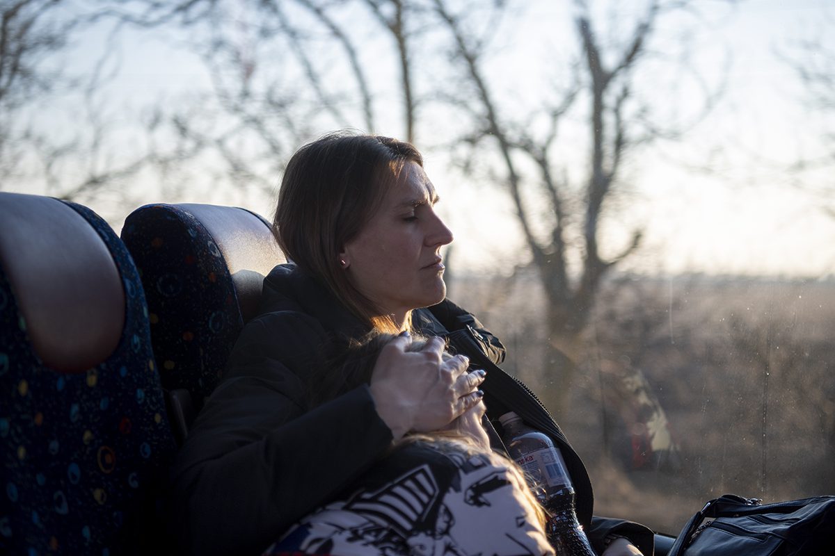 A woman holding her child on a bus