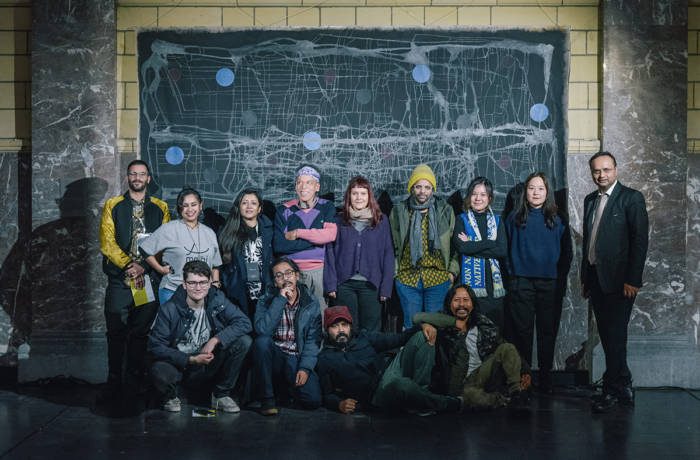 A group of people standing together in front of an artwork