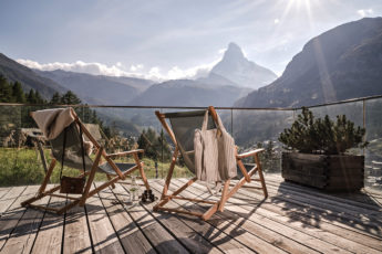 Two deck chairs on a terrace with a view of the Matterhorn in the sun