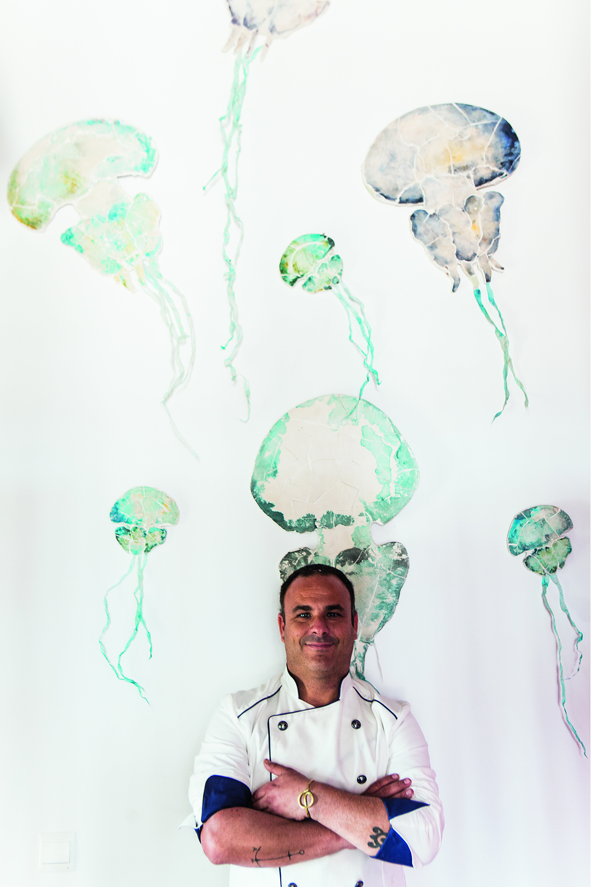 A chef standing in front of a wall with painted blue jellyfish