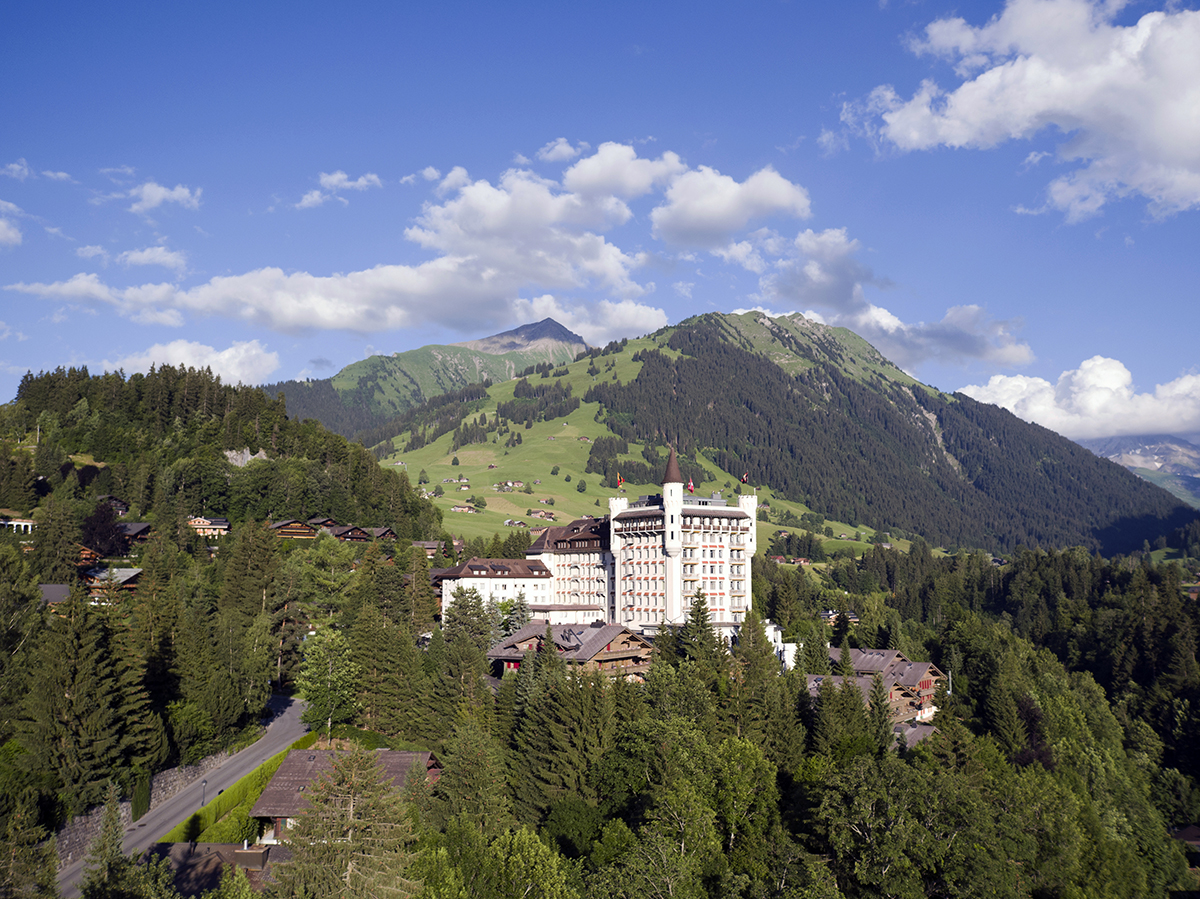 A palace in the mountains with trees around it