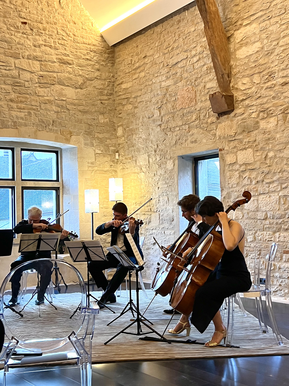 an orchestra playing in a white stone room
