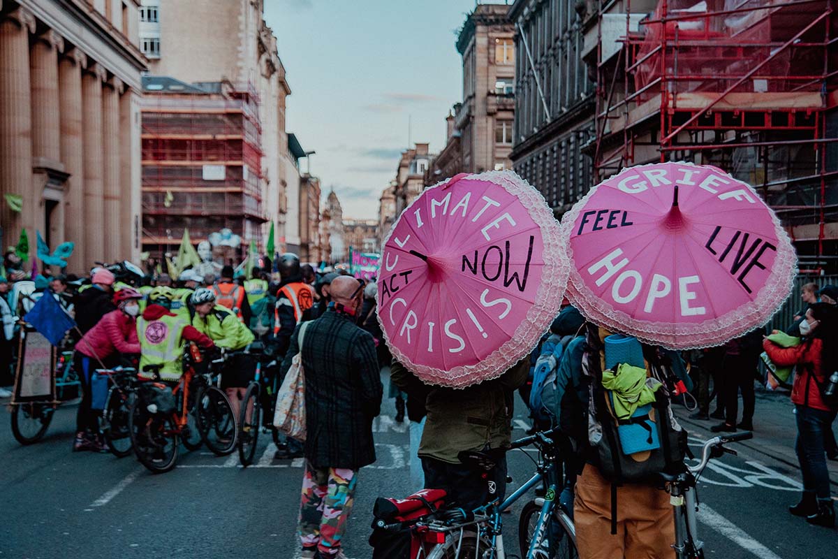 pink umbrellas in a town with people in a climate change protest