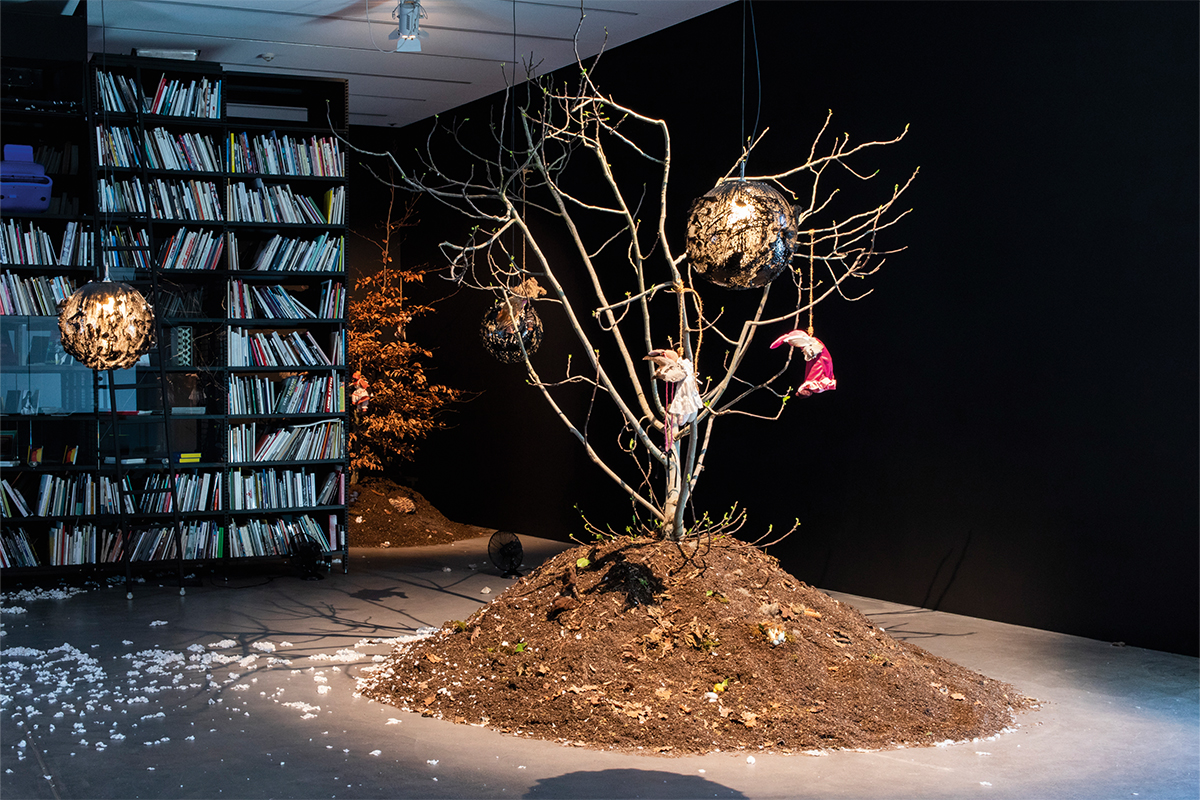 An art installation with twigs and soil in a room