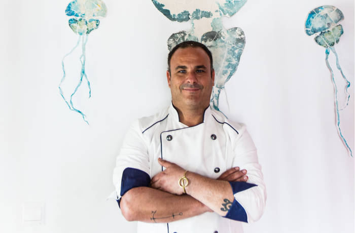 A chef standing in front of a wall with painted blue jellyfish