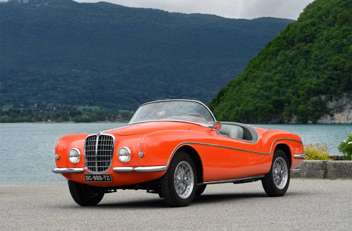 red classic car by a lake