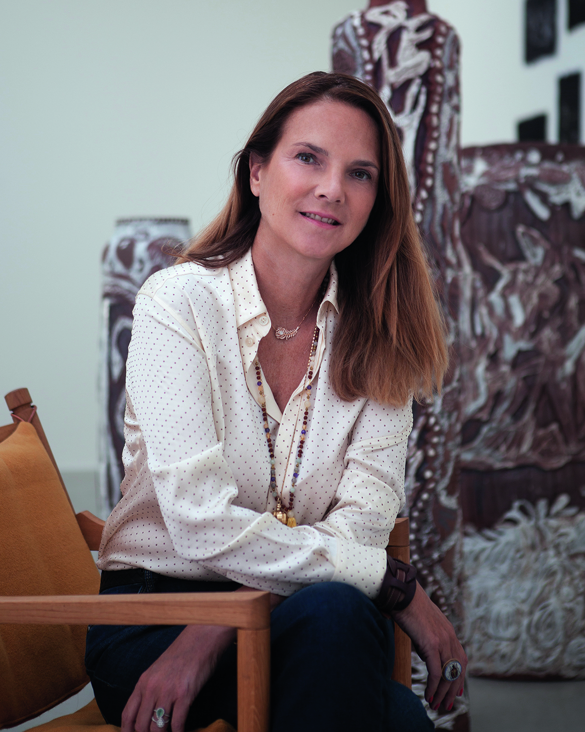 a woman wearing a white shirt sitting on a brown chair