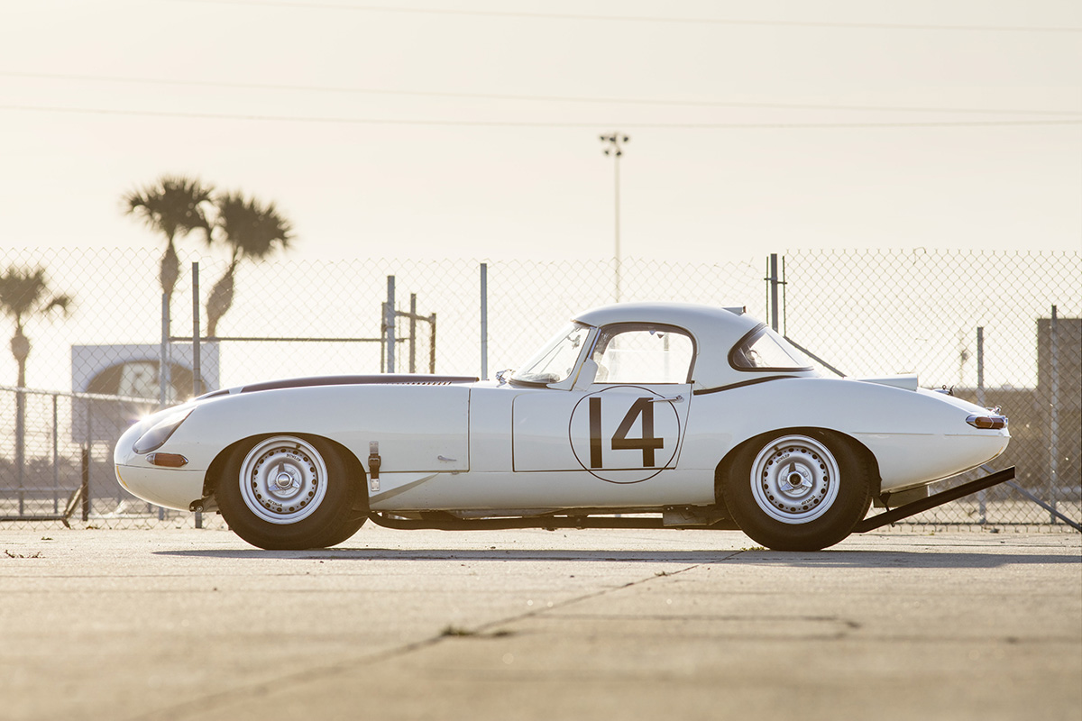 An old white car with the number 14 on the side on a track 