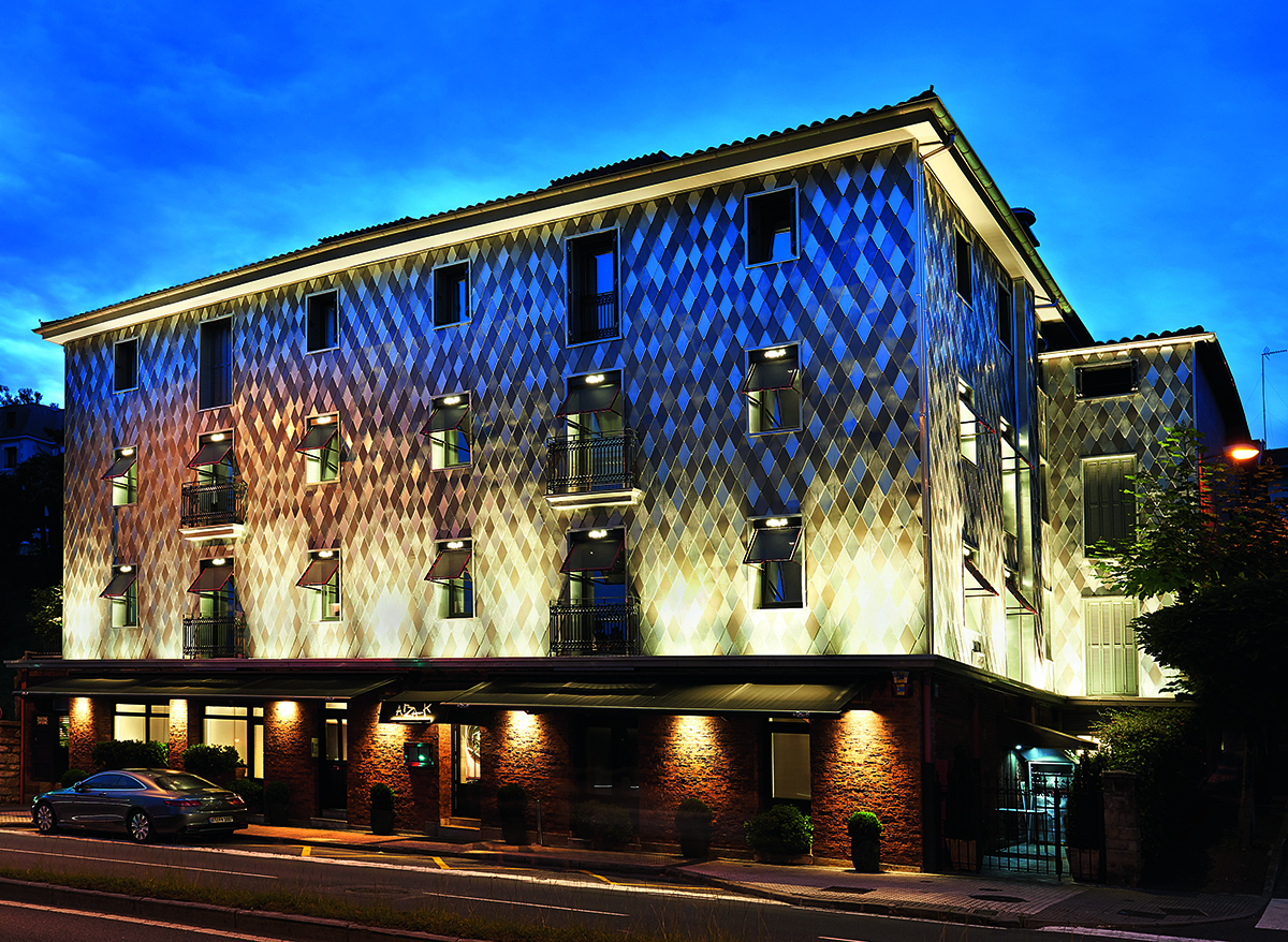 A lit up restaurant at night with a blue sky