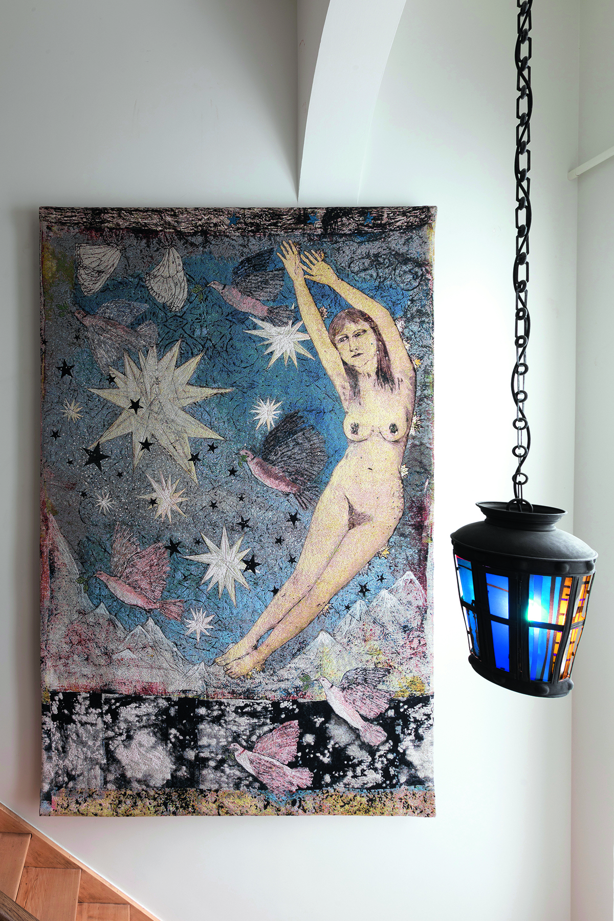 an artwork on a wall with a lamp hanging by it