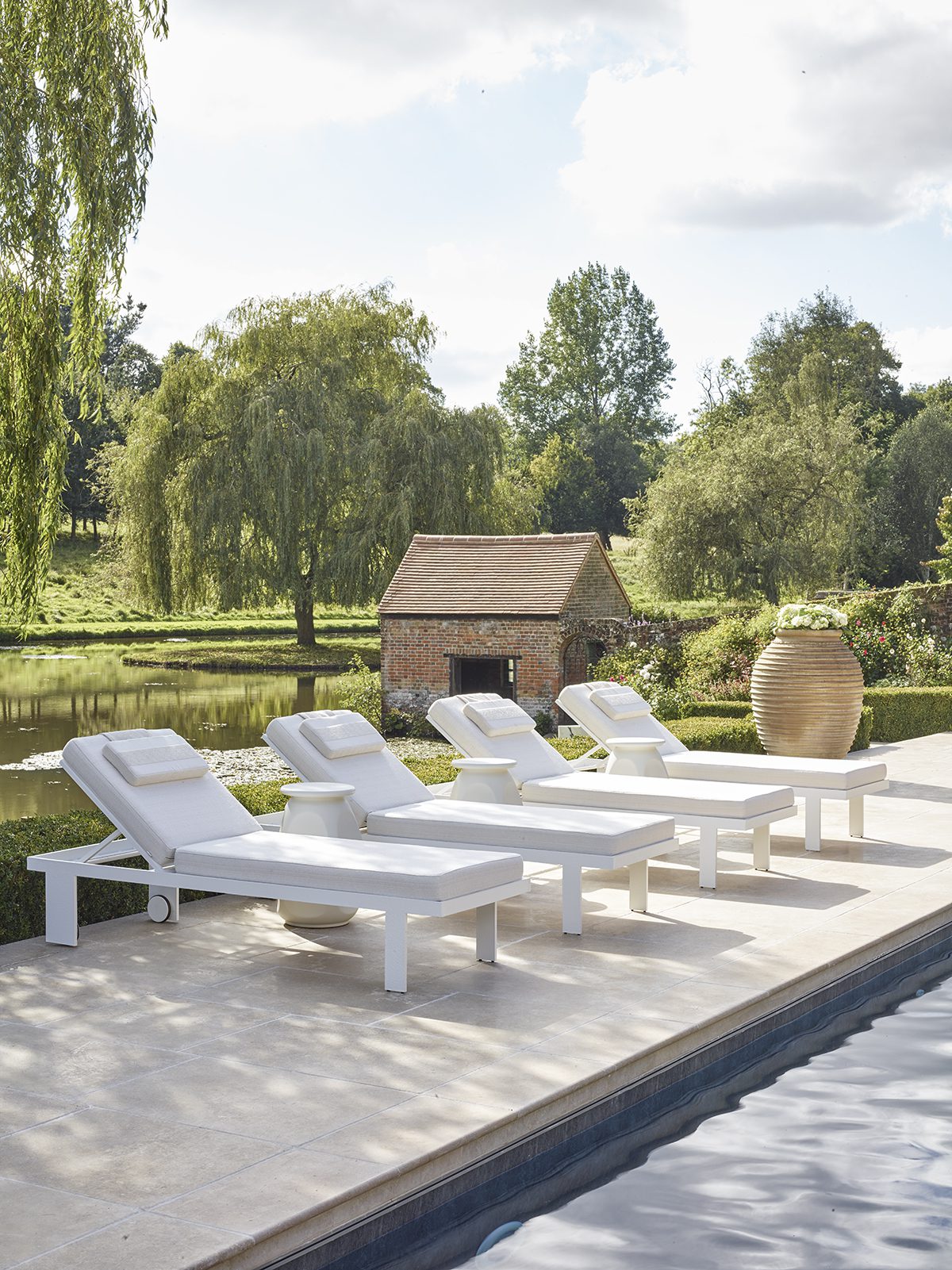 white deckchairs in front of a hut and grass