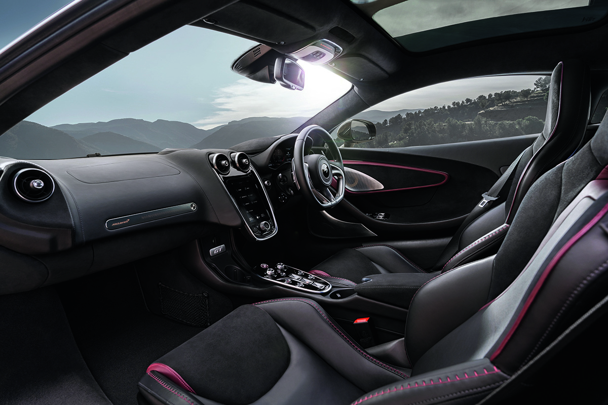 interior black seats and wheel with a red stitching in a McLaren GT