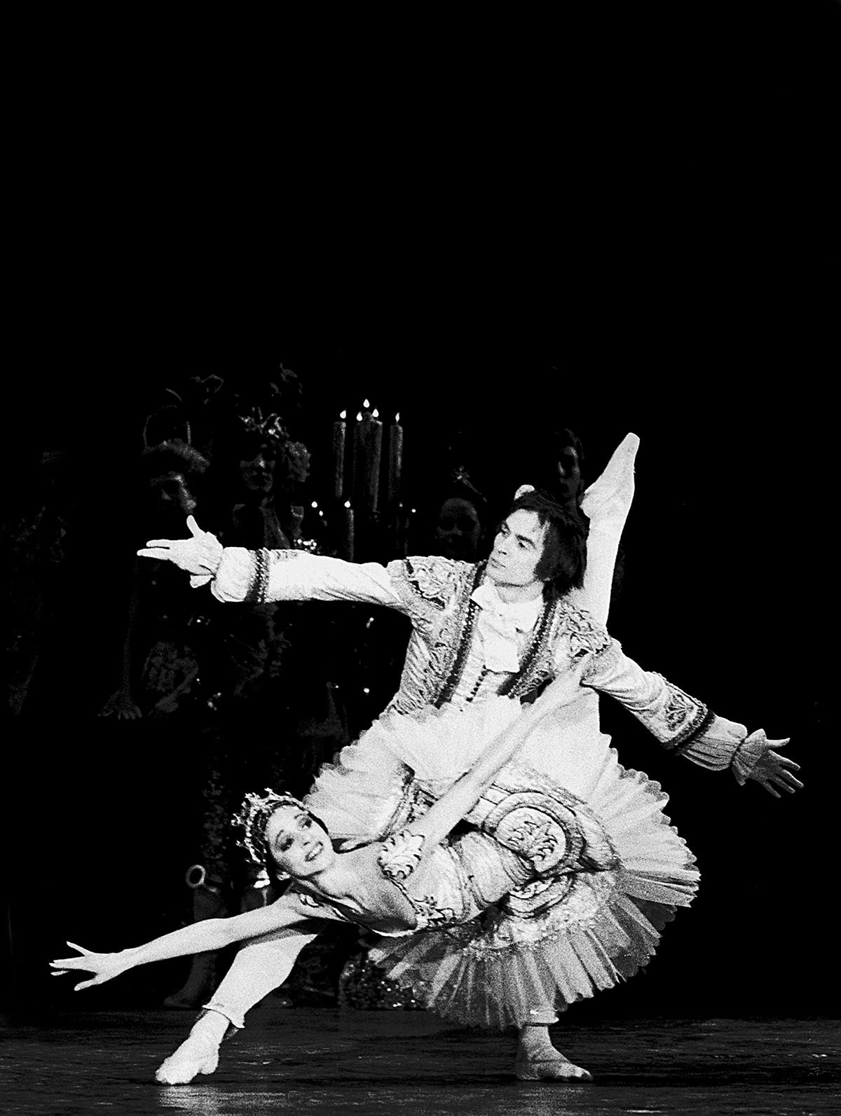 A black and white photo of ballerinas performing on a stage in costumes