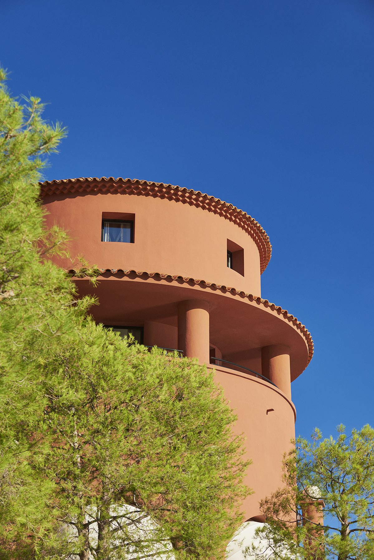 An orange building with a green tree in front of it 