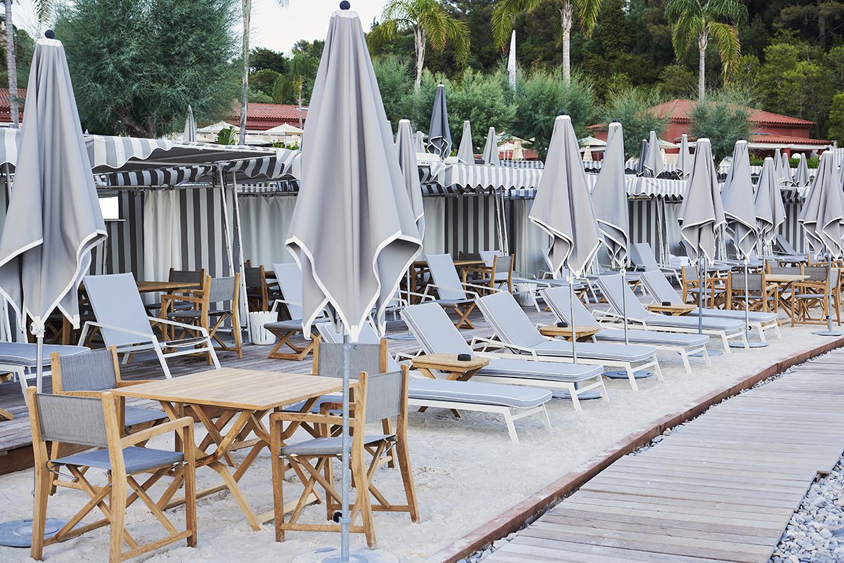 Grey and wooden umbrellas and deckchairs on a beach