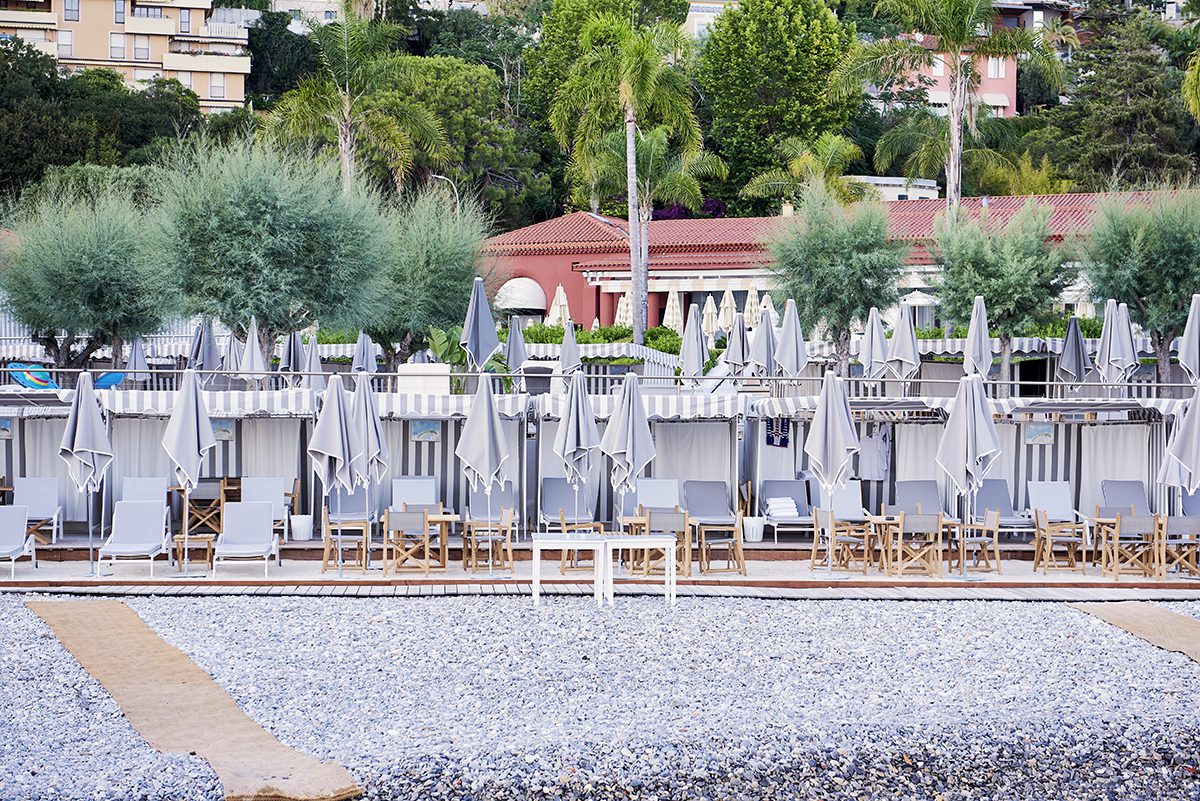 Grey and wooden umbrellas and deckchairs on a beach